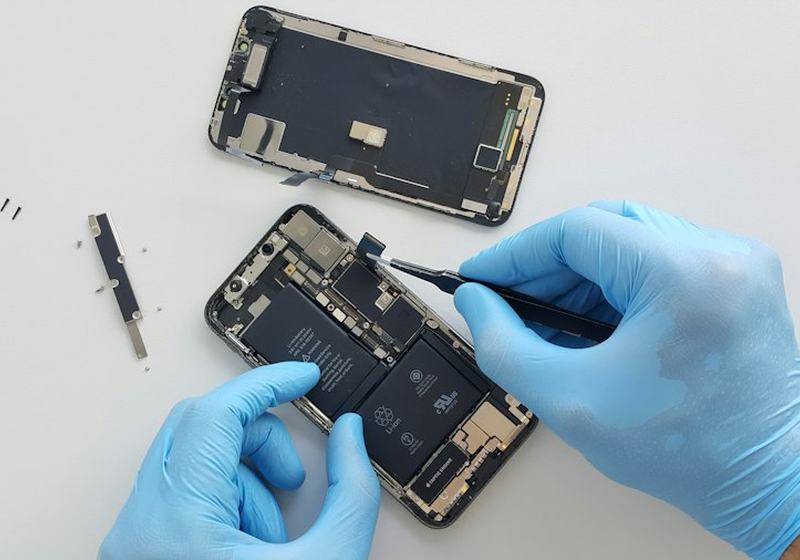 Technician in gloves repairing a smartphone